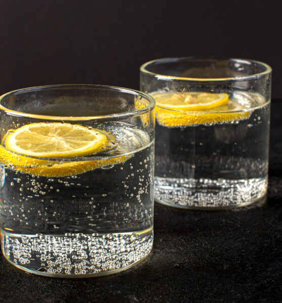 front-closed-up-view-water-with-lemon-fresh-cool-drink-with-sliced-lemons-inside-transparent-glasses