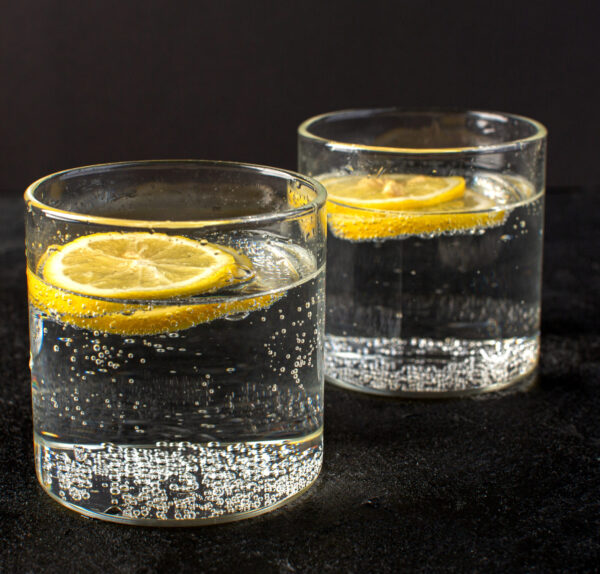 front-closed-up-view-water-with-lemon-fresh-cool-drink-with-sliced-lemons-inside-transparent-glasses