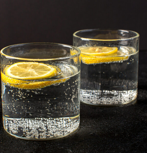 front-closed-up-view-water-with-lemon-fresh-cool-drink-with-sliced-lemons-inside-transparent-glasses